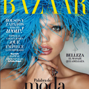 Porta de revista Haper´s Bazaar con logo amaillo. Rostro de una mujer joven con ojos azules. Lleva sobre la cabeza una peluca de plumas azules