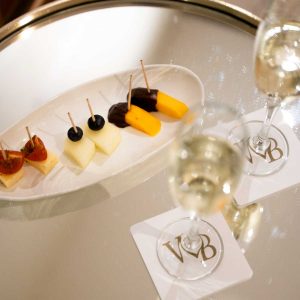 Fota de un aperitivo en Wellness Boutique. se ve un surtido de brochetas de frutas con 2 copas de cava