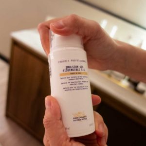 Manos de la terapeuta abriendo un bote de emulsión gel Biosensible S.R de la M